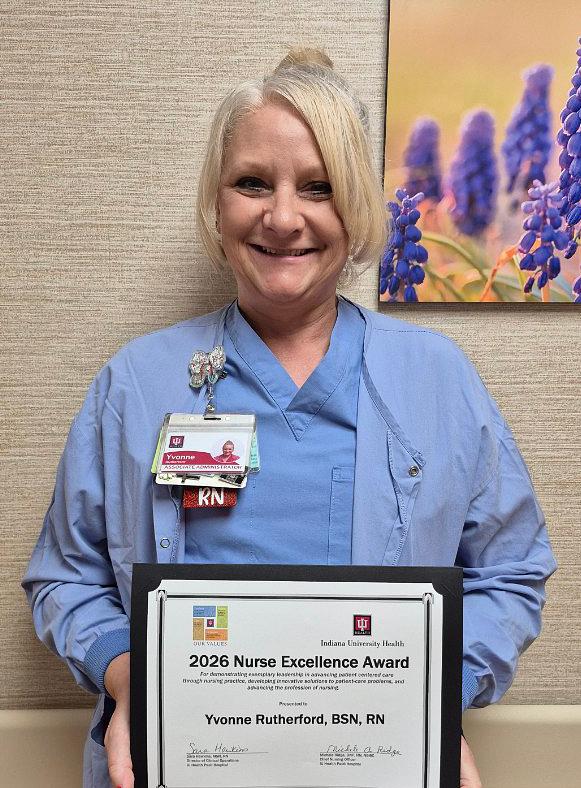 Yvonne Rutherford, RN, holding her Nurse Excellence Award certificate